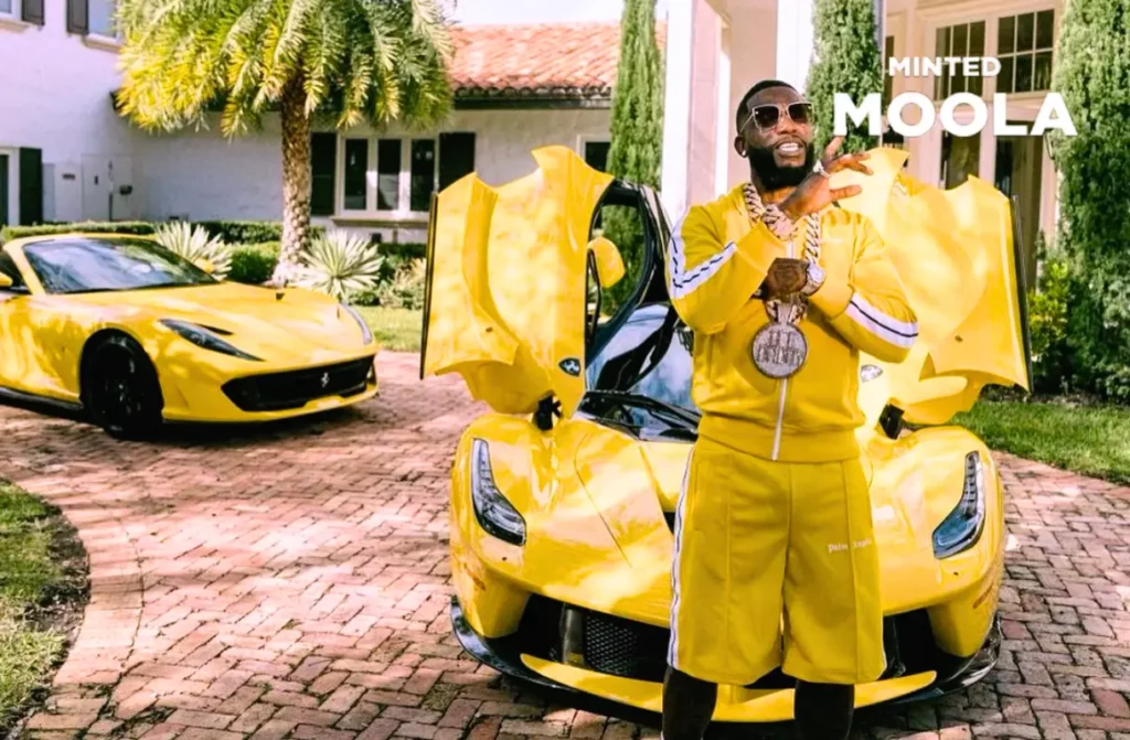 Gucci Mane in front of his car collection with a rare LaFerrari